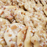 A close-up view of pralines mixed with chopped nuts, filling the entire frame.